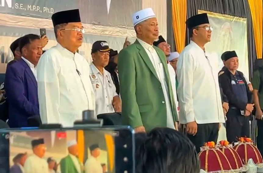 Calon Presiden nomor urut 1 Anies Rasyid Baswedan (kanan) bersamaWakil Presiden ke-10 dan ke-12 HM Jusuf Kalla (kiri) dan pimpinan Pondok Pesantren DDI Mangkoso AG HM Faried Wadjedy (tengah) menyayikan lagu kebangsaan Indonesia Raya jelang dialog kebangsaan rangkaian Milad Pondok Pesantren DDI Mangkoso ke 85 tahun di Kabupaten Barru, Sulawesi Selatan, Rabu (17/1/2023). (Tangkap layer Instagram @ddimangkosoofficial)