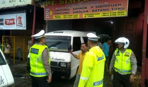 Petugas kepolisian menertibkan bus yang parkir di Jalan Sisingamangaraja Medan.(istimewa)