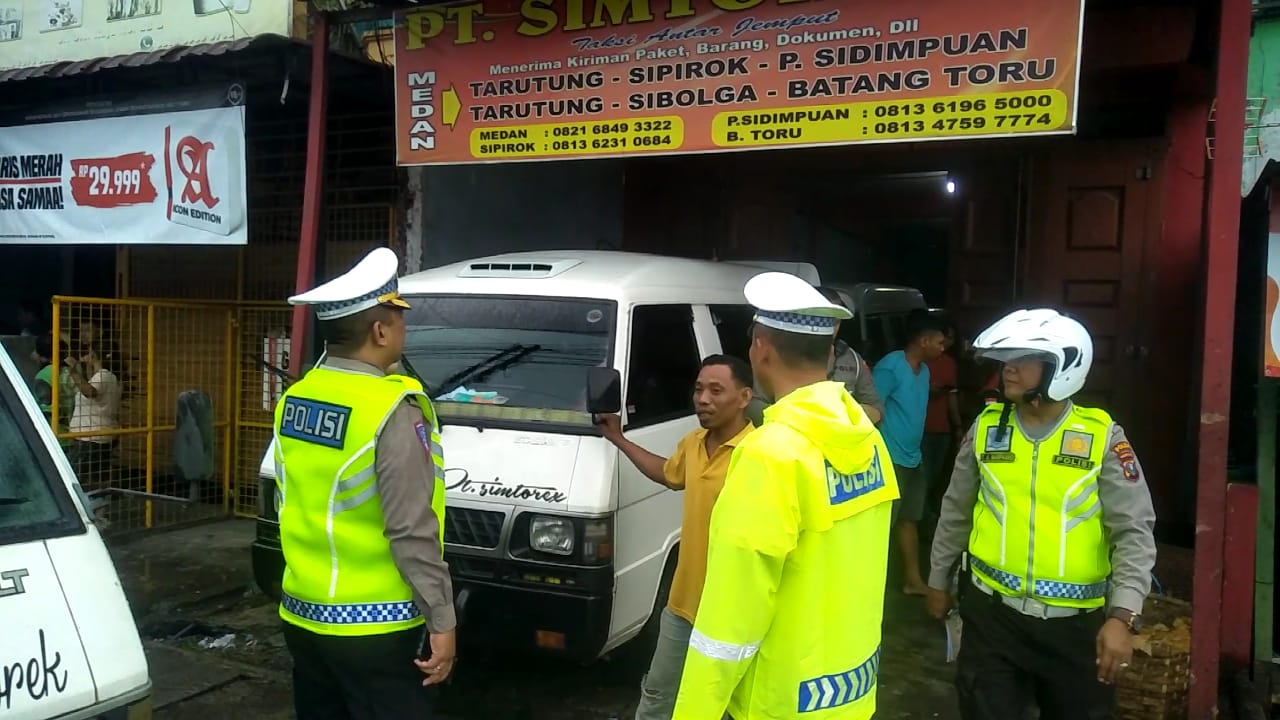 Petugas kepolisian menertibkan bus yang parkir di Jalan Sisingamangaraja Medan.(istimewa)
