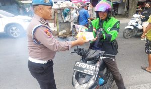 petugas kepolisian membagikan bingkisan makanan dan minuman kepada masyarakat.(istimewa).
