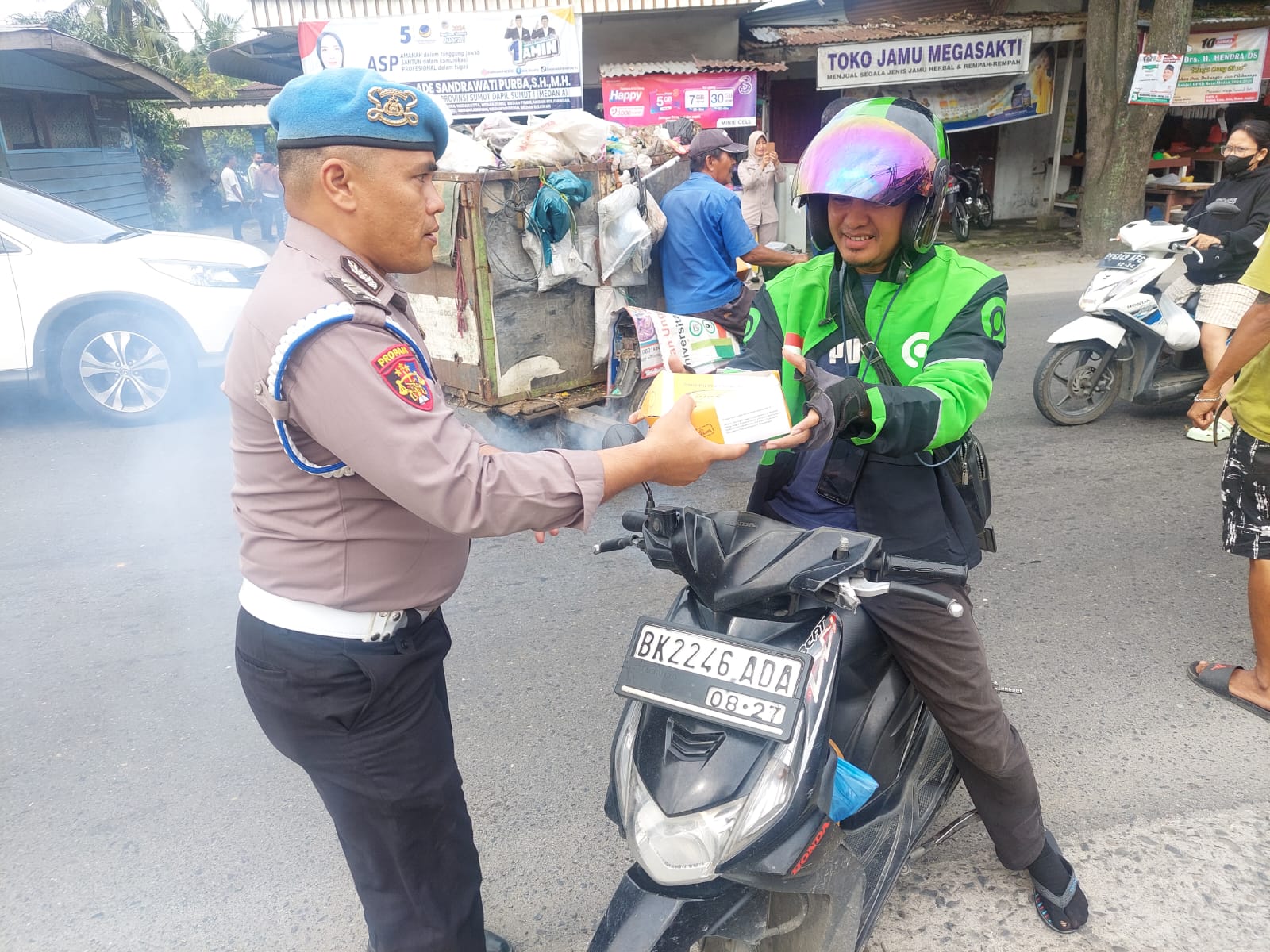 petugas kepolisian membagikan bingkisan makanan dan minuman kepada masyarakat.(istimewa).