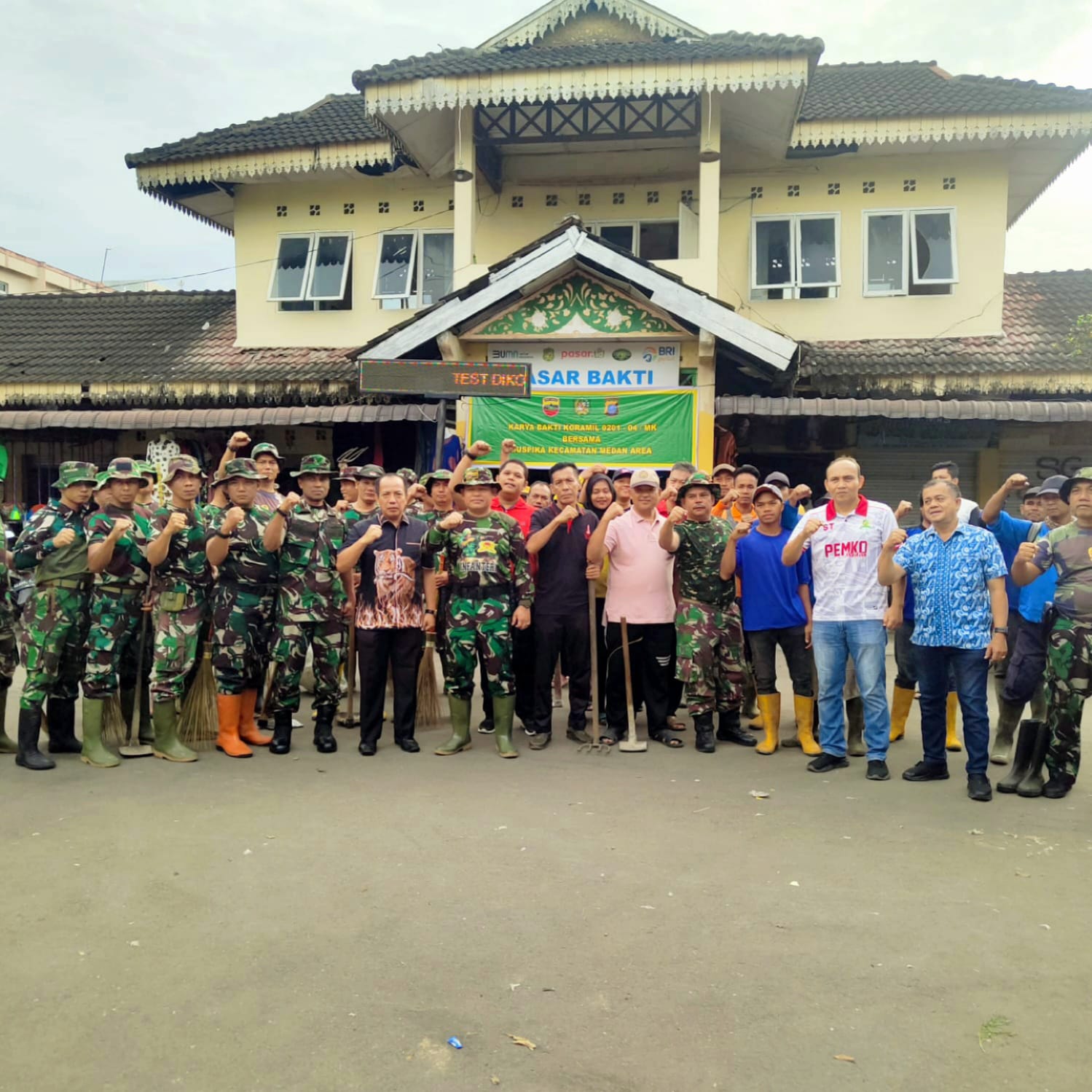 Dirut PUD Pasar Medan Suwarno diwakili Kacab 1 Agus foto bersama saat karya bakti di 2 pasar. BP/erwan
