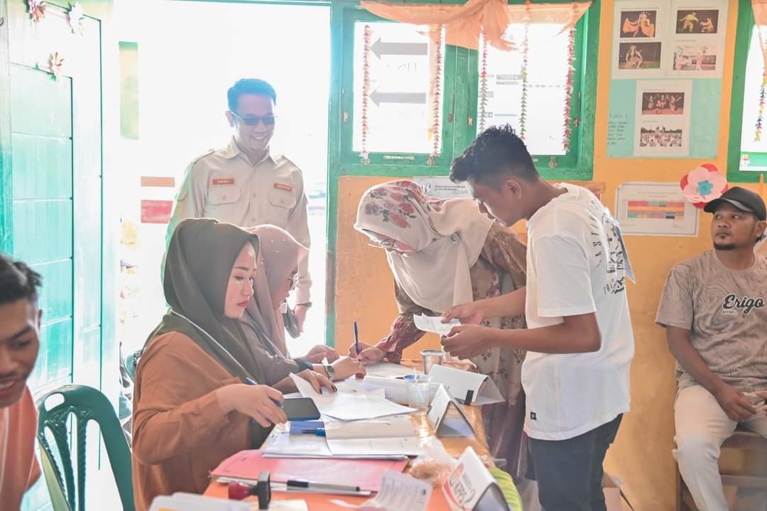 Plt Sekdako Padangsidimpuan Roni Gunawan Rambe dan Istri saat mendaftar kehadiran untuk pergunakan hak pilihnya di TPS 26 Aek Tampang, Rabu (14/2-24). Foto : BP/Ist