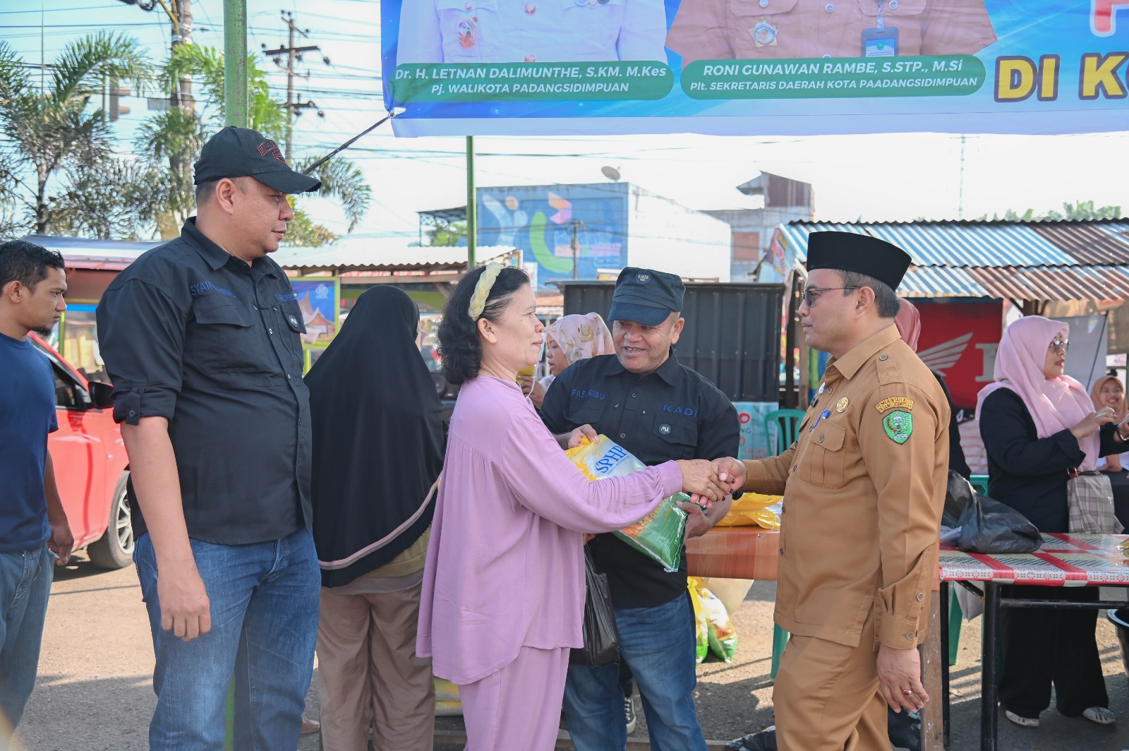 Pj Wali Kota Padangsidimpuan Letnan Dalimunthe ikut melayani pembeli pada GPM di Pasar Padangmatinggi, Senin (5/2-24). Foto : BP/Ist