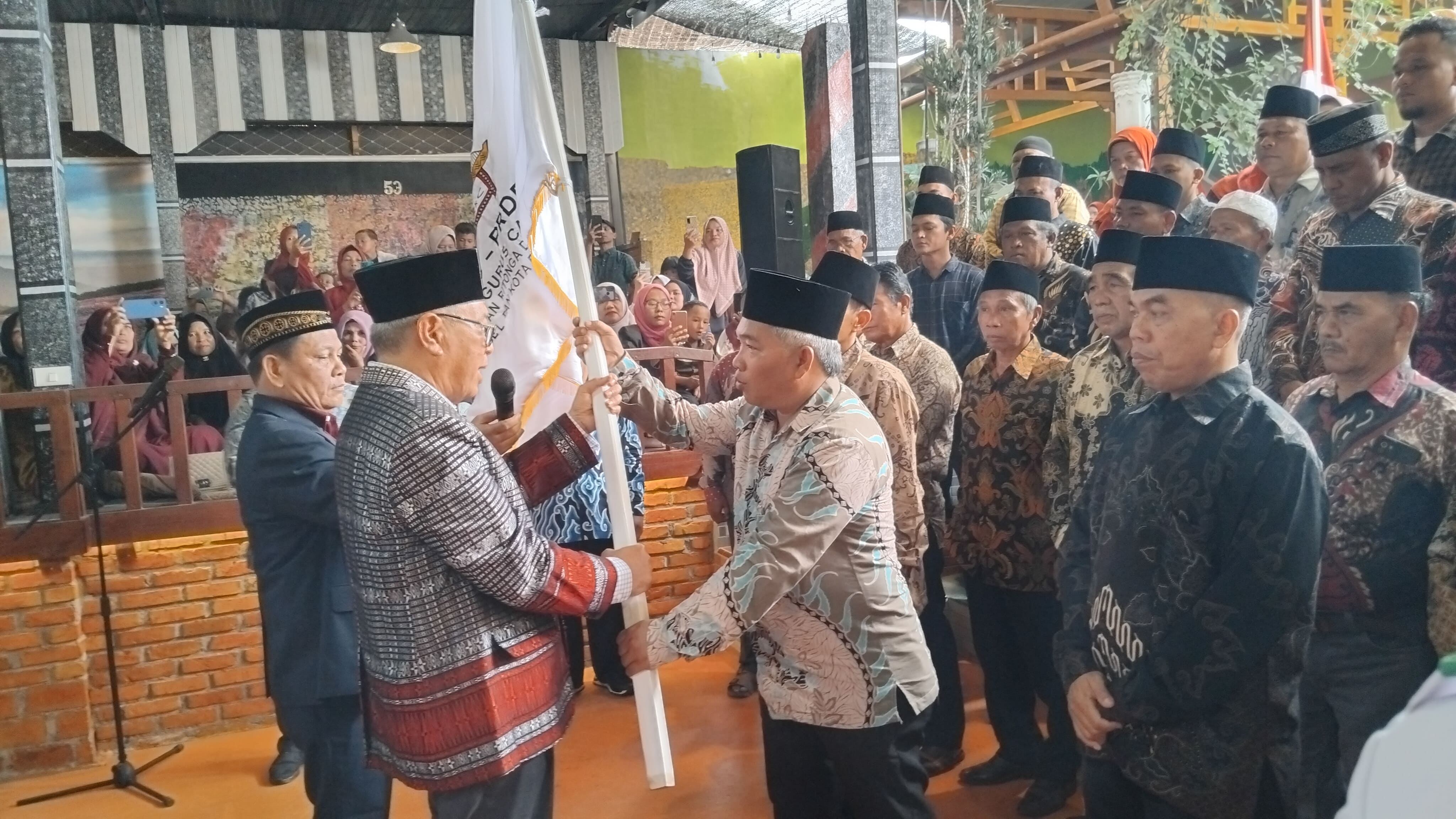 Ketua Umum PB PRDB, Hasban Ritongan saat menyerahkan Bendera Pataka PRDB kepada Ketua yang baru dilantik Asman Ritonga, Sabtu (3/2-24). Foto : BP/Ist