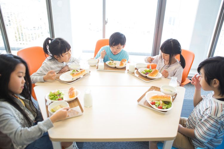 Ilustrasi program makan siang di sekolah Jepang. Shokuiku atau edukasi makan di jam makan siang. Praktik baik ini diajarkan untuk membudayakan makan sehat sejak dini. (Shutterstock/Prostock-studio)