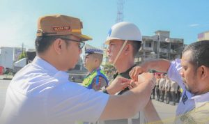 Plt Sekdako Padangsidimpuan saat menyematkan pita operasi kepada perwakilan pasukan operasi Keselamatan Toba 2024 di Alaman Bolak Padang Nadimpu, Rabu (13/3-24). Foto : BP/Ist