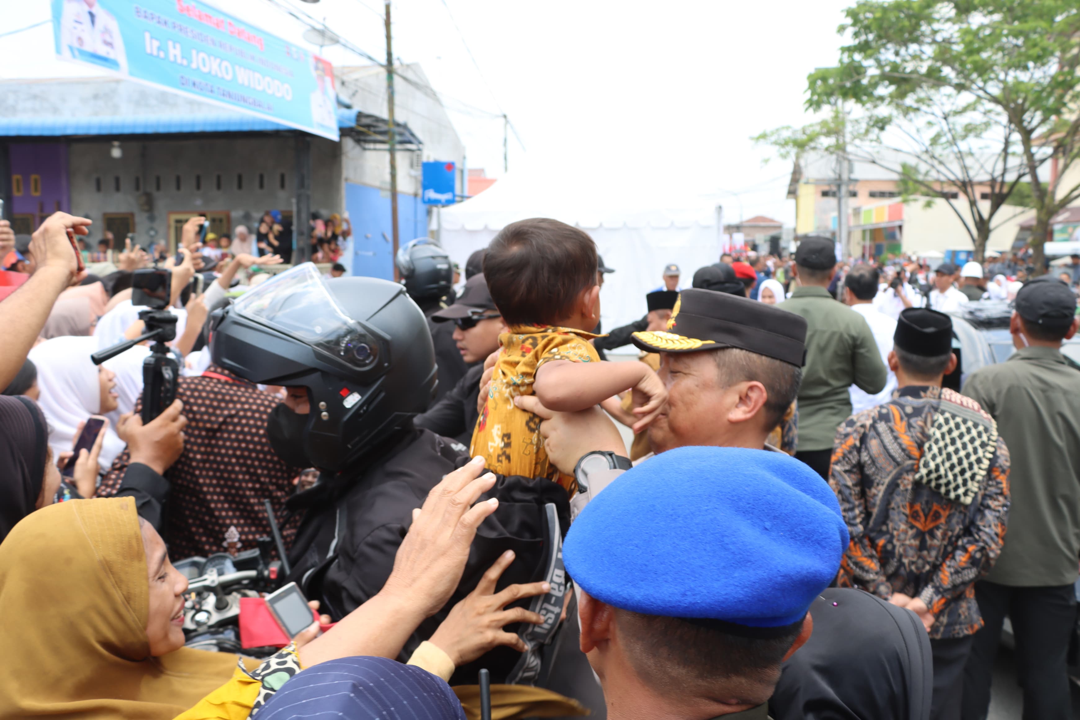 Kapolda Sumut menggendong seorang anak warga yang antusias melihat kehadiran Presiden RI Joko Widodo.(Istimewa)
