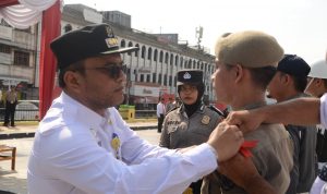 Pj Wali Kota Padangsidimpuan Letnan Dalimunthe saat memasang tanda pita kepada salah seorang perwakilan personil Ketupat 2024 dalam Apel Pasukan di Alaman Bolak, Rabu (3/4-24). Foto ; BP/Ist