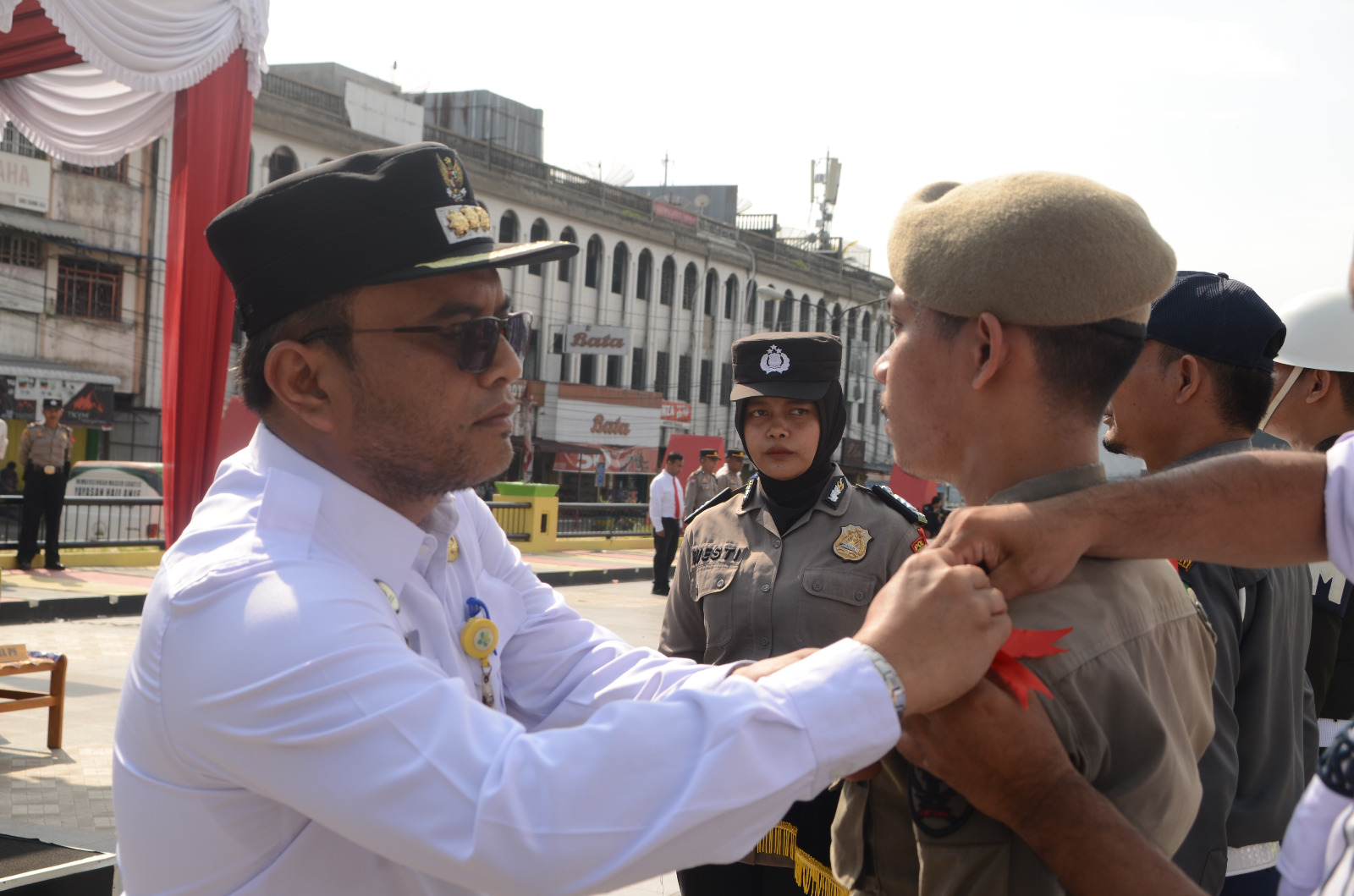 Pj Wali Kota Padangsidimpuan Letnan Dalimunthe saat memasang tanda pita kepada salah seorang perwakilan personil Ketupat 2024 dalam Apel Pasukan di Alaman Bolak, Rabu (3/4-24). Foto ; BP/Ist