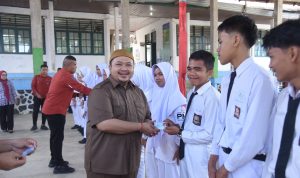 Bupati Tapsel Dolly Pasaribu saat menyerahkan e-KTP secara simbolis pada siswa-siswi di SMAN 1Angkola Barat, Jum'at (26/4-24). Foto : BP/Ist