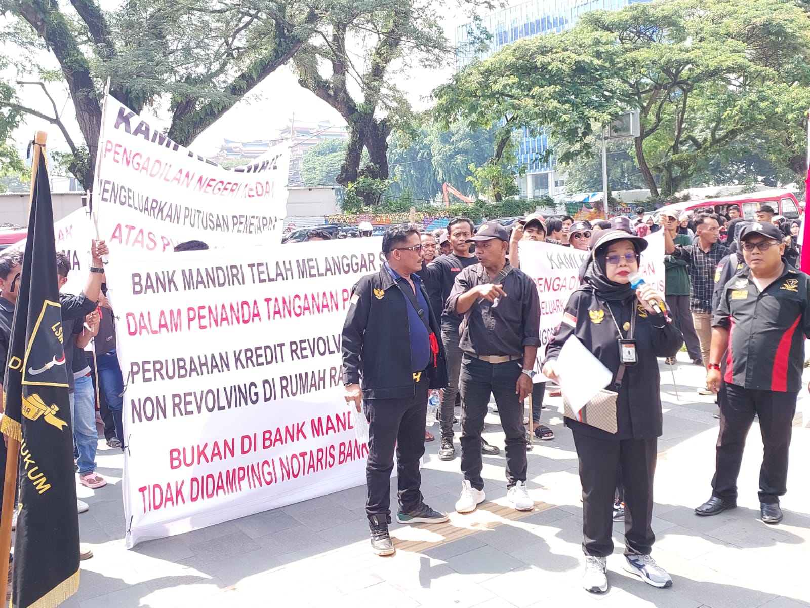 Penasehat hukum Hj. Tri Atnuari, SH, M. HUM saat orasi di depan Bank Mandiri Jalan Balai Kota Medan, Senin (27/5/2024). BP/erwan