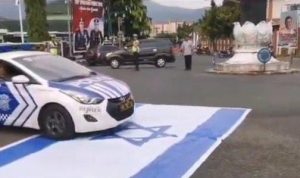mobil Patwal polisi melindas bendera Israel saat mengamankan aksi damai Banjarnegara Peduli Palestina, Minggu (23/6/2024).