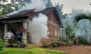 BERASAP: Petugas memfogging rumah warga untuk memutus mata rantai nyamuk DBD. (DINKESDALDUK KB TRENGGALEK UNTUK RADAR TRENGGALEK)