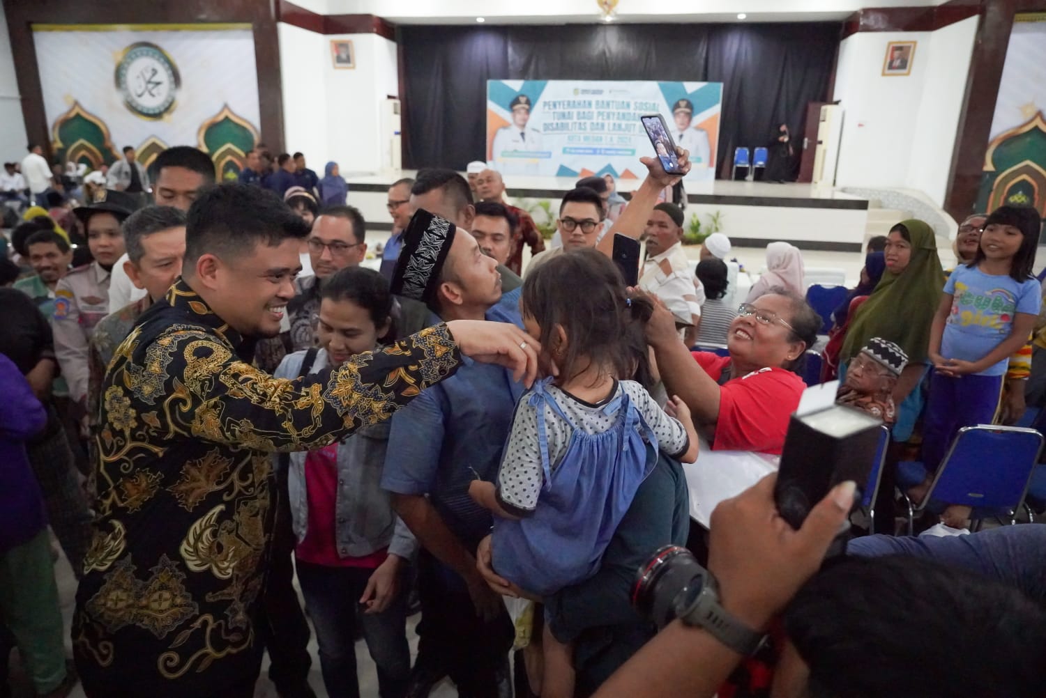 Wali Kota Medan Bobby Nasution saat menyerahkan Bantuan Sosial Tunai (BST) kepada disabilitas dan jompo. BP/erwan