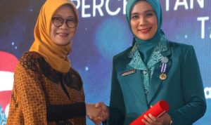 Ketua TP PKK Tapsel Ny Rosalina Dolly Pasaribu saat menerima penghargaan yang diserahkan Deputi Meneko PMK RI, di Semarang, Jum'at (28/6-24) malam. Foto : BP/Ist