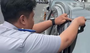 Petugas dishub Medan memasang stiker parkir Berlangganan ke mobil.