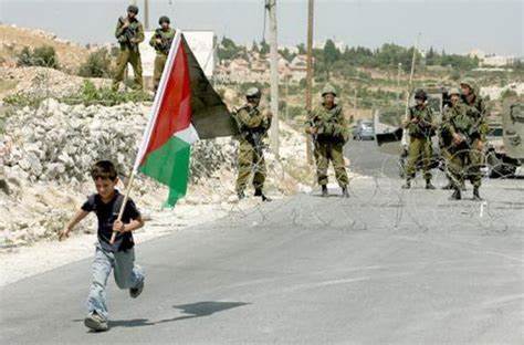 Anak Palestina memegang bendera Palestina didepan tentara zionis Yahudi.