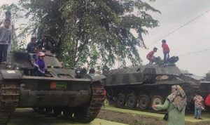 Anak-anak bermain dan berfoto di atas tank yang terparkir di taman Cadika Medan Johor.