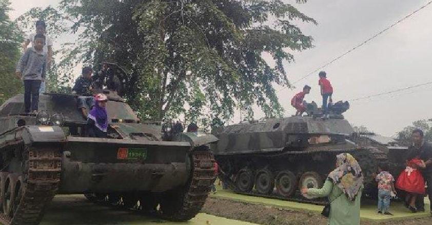 Anak-anak bermain dan berfoto di atas tank yang terparkir di taman Cadika Medan Johor.
