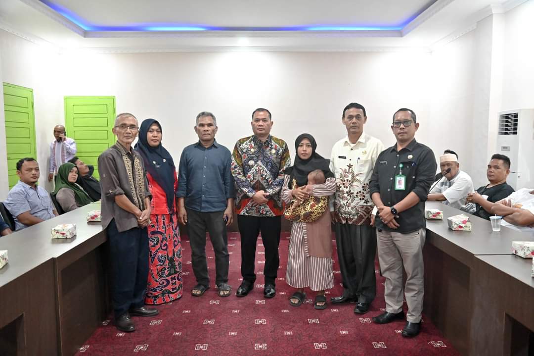 Pj Wali Kota Padangsidimpuan, Timur Tumanggor didampingi Kadis Sosial, Kalaksa BPBD dan Sekretaris Kominfo foto bersama dengan korban kebakaran usai penyerahan bantuan, Kamis (18/7-24). Foto : BP/Ist