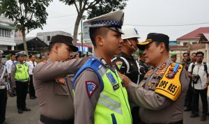 Kapolres Padangsidimpuan AKBP Dudung Setyawan SH, SIK, MH memasang pita kepada salah seorang personil Lantas Polres Padangsidimpuan, Senin (15/7-24). Foto : BP/Ist