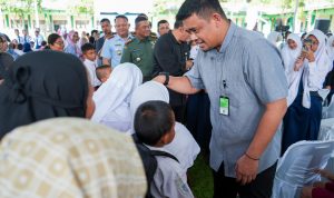 Wali Kota Medan Bobby Nasution saat menyerahkan bantuan seragam sekolah kepada siswa. BP/erwan