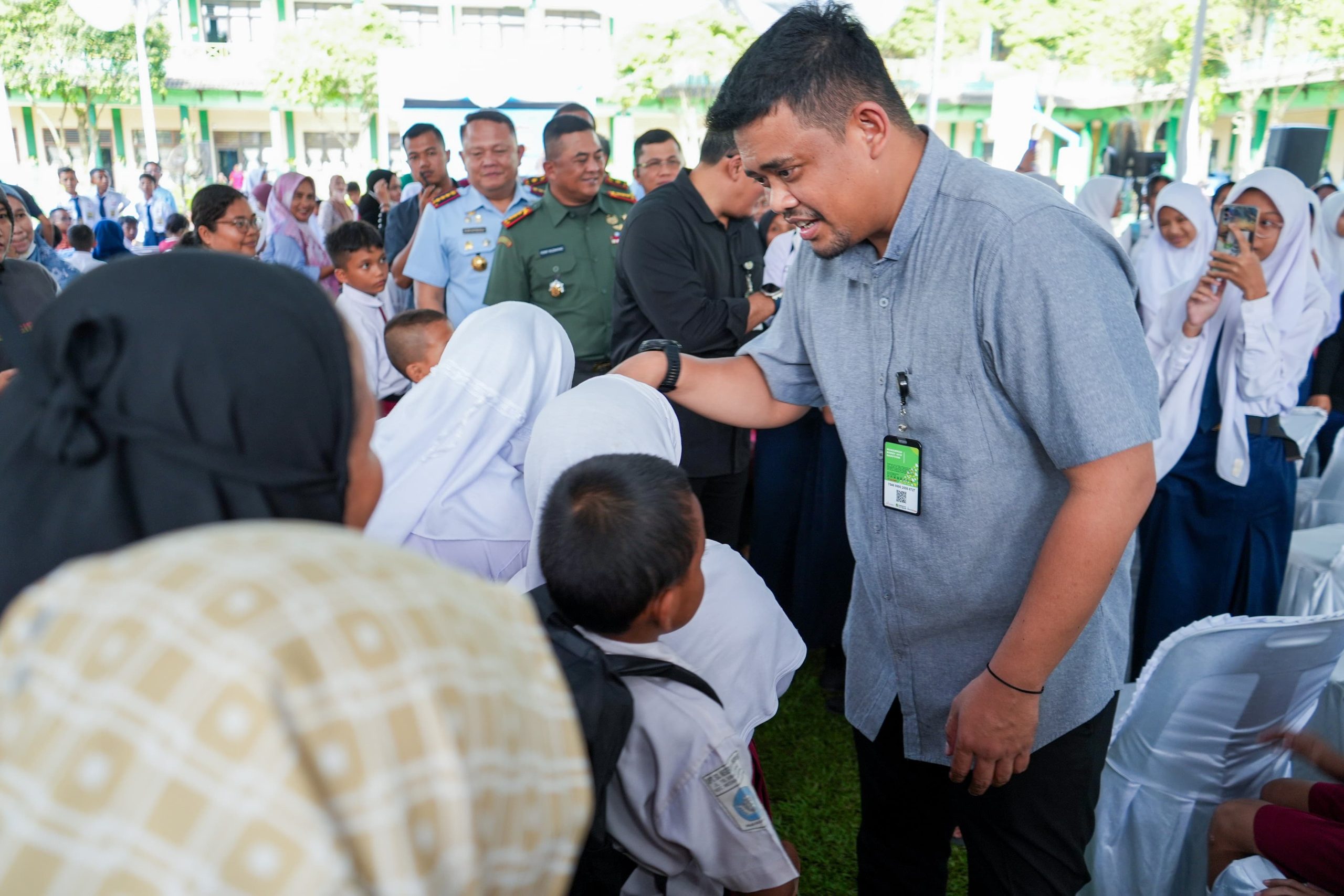 Wali Kota Medan Bobby Nasution saat menyerahkan bantuan seragam sekolah kepada siswa. BP/erwan
