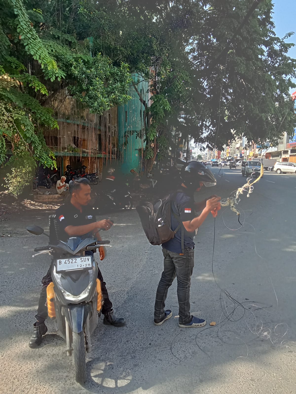 Dua petugas Indohome menata kabel yang terjuntai di Jalan Sutomo dekat pintu masuk Pasar Pusat Pasar Medan. BP/erwan