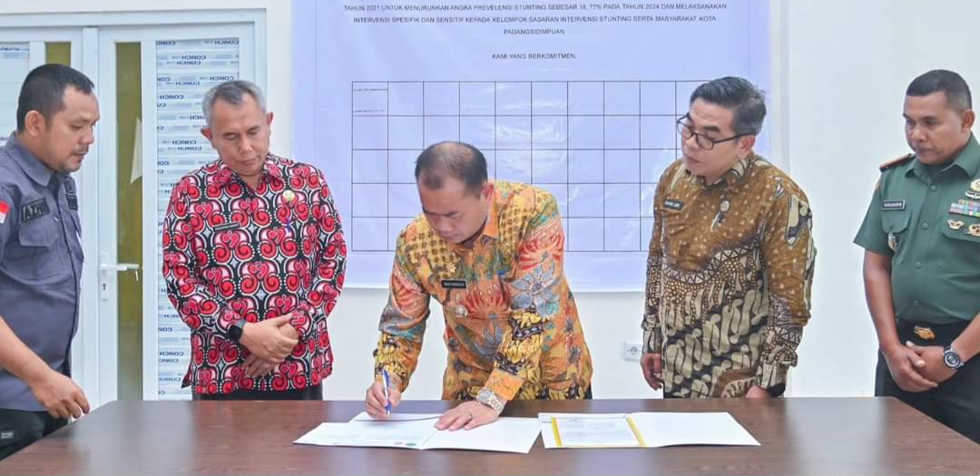 Pj Wali Kota Padangsidimpuan Timur Tumanggor saat menandatangani hasil Rembuk Stunting, Kamis (8/8-24). Foto : BP/Ist