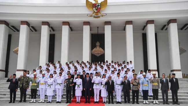 Presiden Joko Widodo (tengah) didampingi sejumlah menteri dan kepala lembaga negara berfoto bersama anggota Paskibraka 2024 seusai dikukuhkan di Istana Negara, Ibu Kota Nusantara (IKN), Kalimantan Timur, Selasa (13/8/2024).