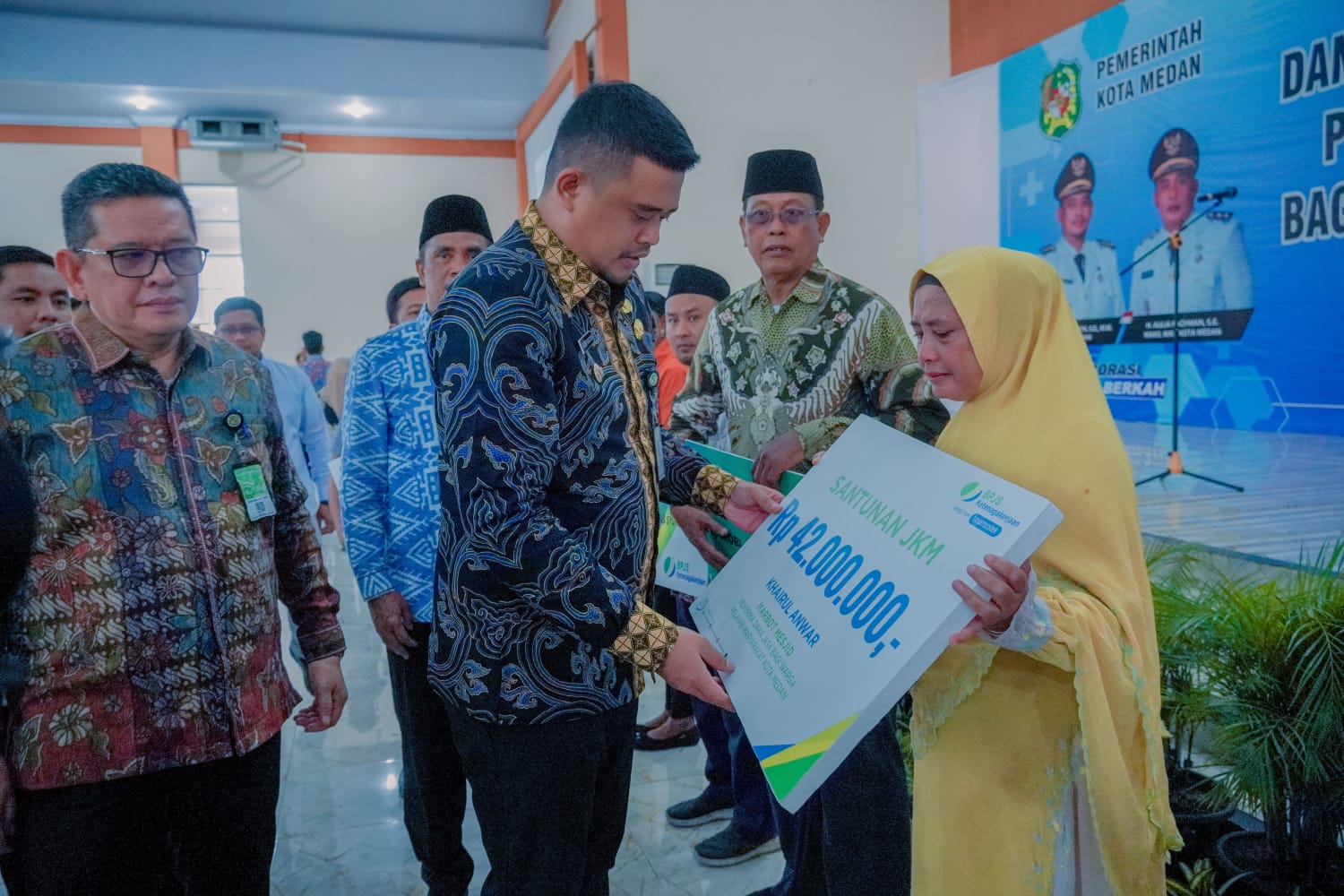 Wali Kota Medan Bobby Nasution saat menyerahkan bantuan bantuan dana DJPM kepada warga. BP/erwan