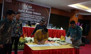 Sedang menandatangani hasil pleno