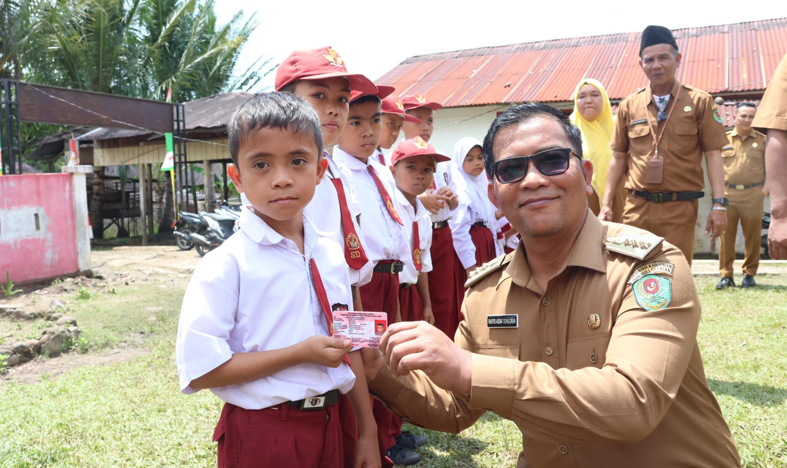 Plt Bupati Tapsel Rasyid Assaf Dongoran saat membagikan KIA kepada siswa SDN 100313, Senin (30/9-24). Foto : BP/Ist