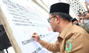 Plt Bupati Tapsel Rasyid Assaf Dongoran saat menandatangani spanduk Deklarasi dan Ikrar Jihad Melawan Narkoba di Masjid Agung Syahrun Nur, Sipirok, Selasa (15/10-24). Foto : BP/Ist