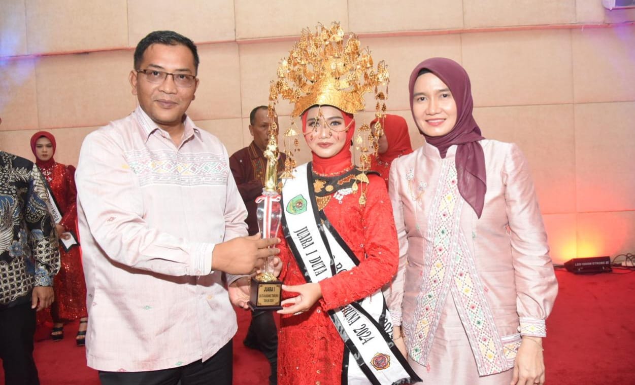 Plt Bupati Tapsel Rasyid Assaf Dongoran dan Plt Ketua TP PKK Tapsel saat menyerahkan tropi kepada pemenang Boru Namora Tapsel, Jum'at (22/11-24) malam. Foto : BP/Ist q
