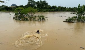 Anggota Polri berenang menyelamatkan korban.(Istimewa)