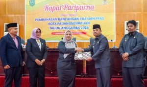 Pj Wali Kota Padangsidimpuan Timur Tumanggor saat menyerahkan dokumen KUA-PPAS APBD Kota Sidimpuan TA 2025 kepada Ketua DPRD Sri Fitrah Munawaroh untuk di bahas lebih lanjut, Senin (2/12-24). Foto : BP/Ist