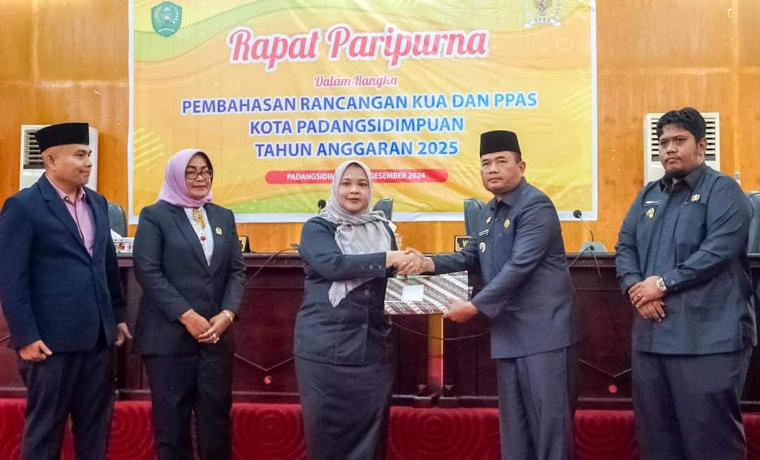Pj Wali Kota Padangsidimpuan Timur Tumanggor saat menyerahkan dokumen KUA-PPAS APBD Kota Sidimpuan TA 2025 kepada Ketua DPRD Sri Fitrah Munawaroh untuk di bahas lebih lanjut, Senin (2/12-24). Foto : BP/Ist