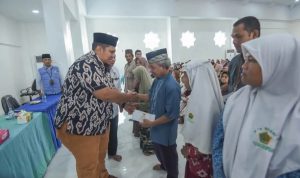 Pj Sekdako Padangsidimpuan, Ary Junaidi saat menyerahkan ZIS kepada yang Mustahik di Aula Kantor Baznas, Kamis (12/12-24). Foto : BP/Ist