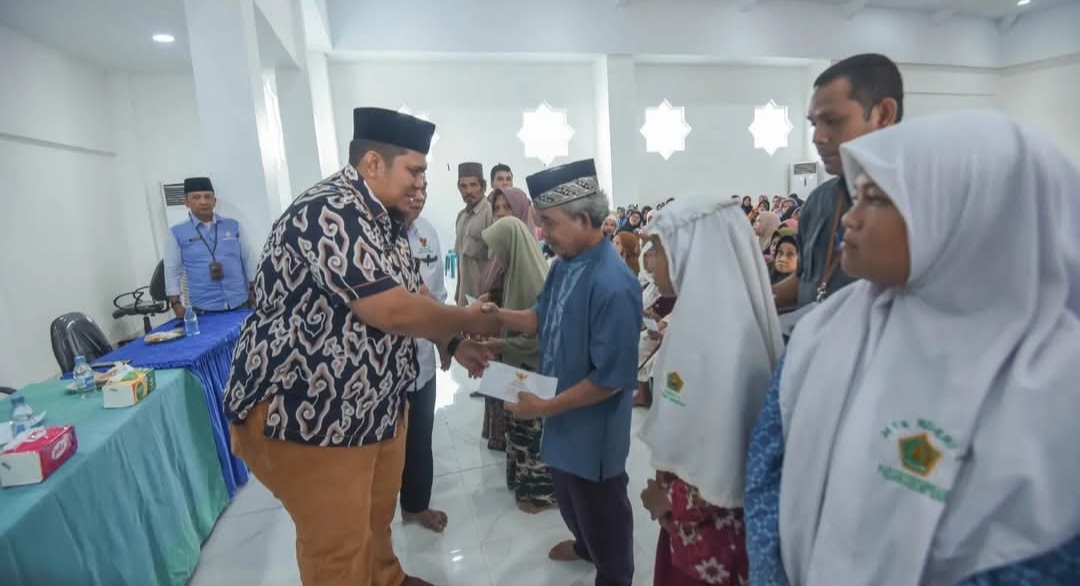 Pj Sekdako Padangsidimpuan, Ary Junaidi saat menyerahkan ZIS kepada yang Mustahik di Aula Kantor Baznas, Kamis (12/12-24). Foto : BP/Ist