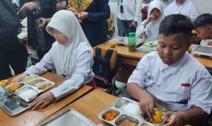 Siswa SD Susukan 01 ketika membuka makan bergizi gratis di SDN 01 Susukan, Ciracas, Jakarta Timur