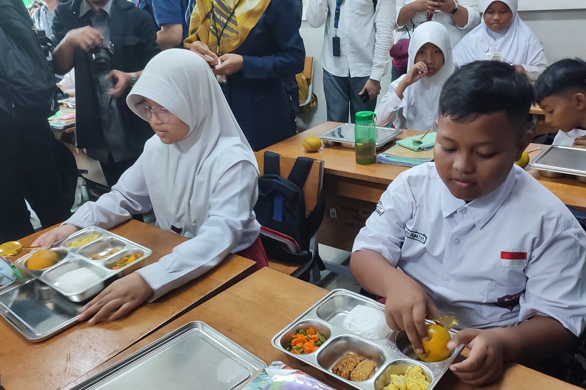 Siswa SD Susukan 01 ketika membuka makan bergizi gratis di SDN 01 Susukan, Ciracas, Jakarta Timur