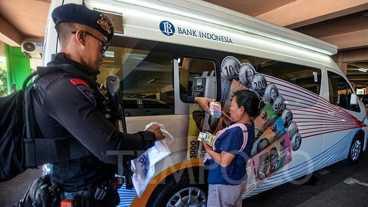 Warga mengantre untuk menukar uang pecahan di mobil kas keliling