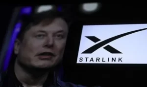Elon Musk terlihat di layar dekat logo Starlink