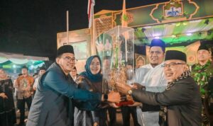 Pj Sekdako Padangsidimpuan, M Ary Junaidi Lubis saat menyerahkan tropi Juara Umum kepada Camat P. Sidimpuan Utara di sela penutupan MTQ ke-XXIV di Terminal Batunadua, Minggu (23/2-25) malam. Foto : BP/Ist