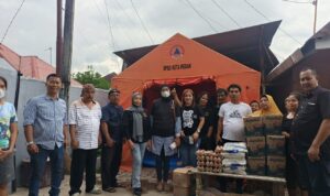 Anggota AMS XII Kota Medan menyerahkan bantuan sembako kepada korban kebakaran. Suasana penuh kepedulian dan kebersamaan.