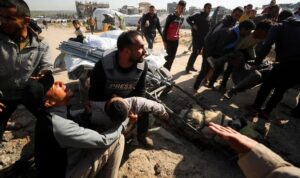 Warga Palestina memegang jenazah jurnalis Hossam Shabat