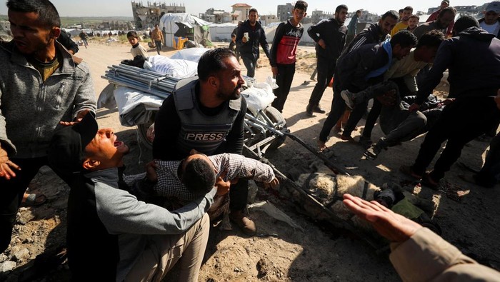 Warga Palestina memegang jenazah jurnalis Hossam Shabat