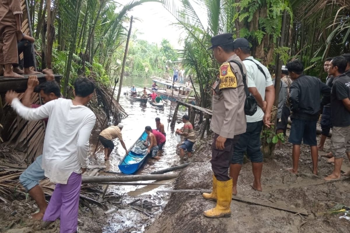Petugas dan warga mengevakuasi jenazah anak yang diduga diterkam buaya di sungai Kepenghuluan Sungai Kubu, Kecamatan Kubu, Kabupaten Rokan Hilir, Riau